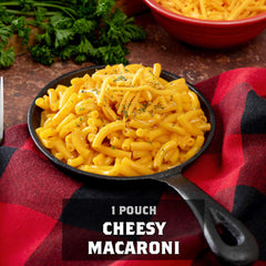 Skillet of cheesy macaroni on red plaid cloth with fresh herbs and title text overlay
